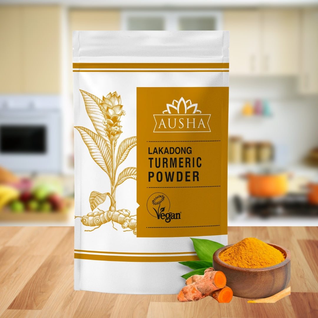Lakadong Turmeric Powder on kitchen counter with bowl of turmeric and whole turmeric roots.