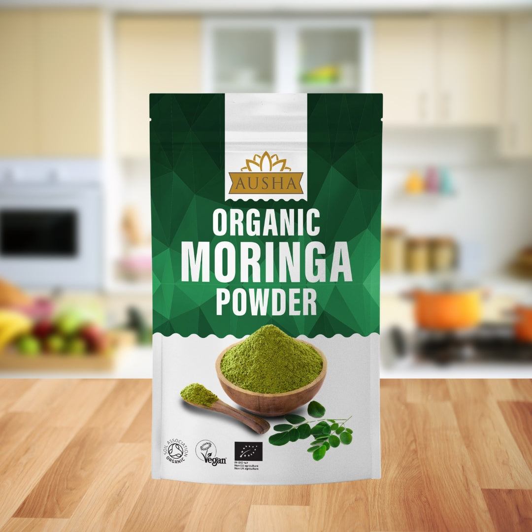 Organic Moringa Powder in green packaging on kitchen counter. Certified organic and vegan.
