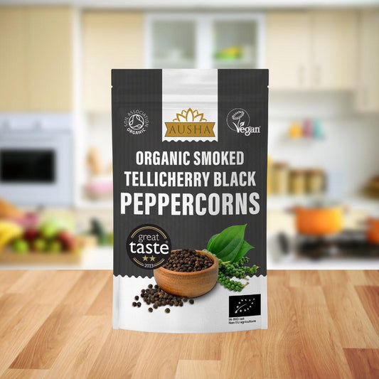 Bag of Organic Smoked Telicherry Black Peppercorns 100g on kitchen counter.