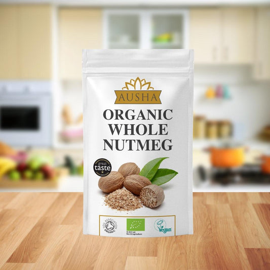 Organic whole nutmeg package on a wooden kitchen countertop.